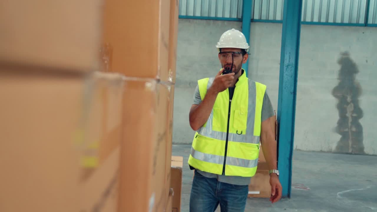 trabajador de carga profesional habla por radio portátil para comunicarse con otro trabajador