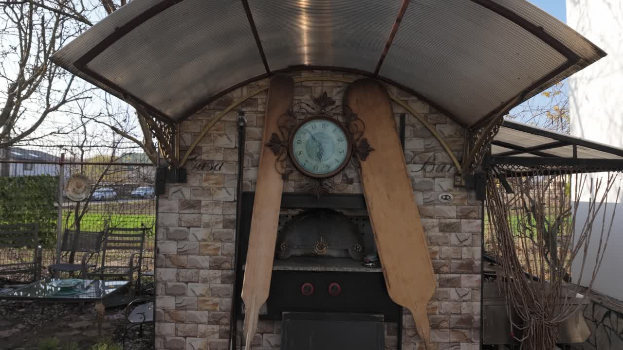 horno de exterior desgastado con un reloj antiguo y paletas de madera altas