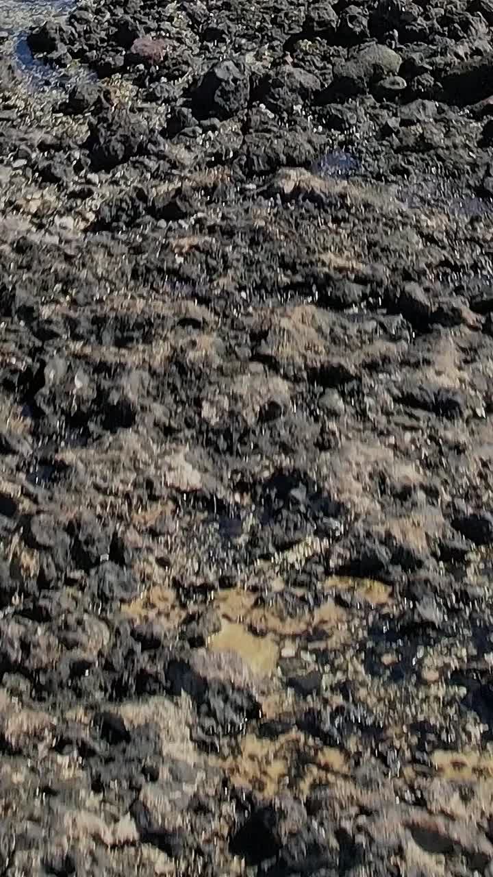 Bezoekers lopen over rotsachtig terrein nabij de kustlijn op de Canarische Eilanden