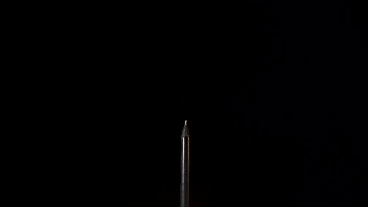 Thin Black Charcoal Pencil Push Out On Black Background - Slow Motion
