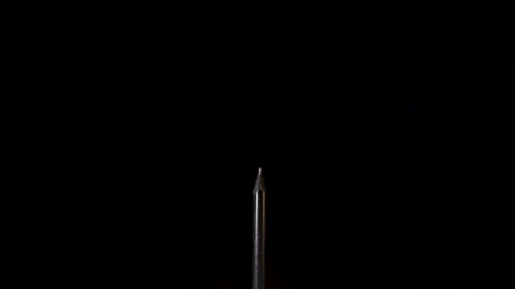 Thin Black Charcoal Pencil Push Out On Black Background - Slow Motion