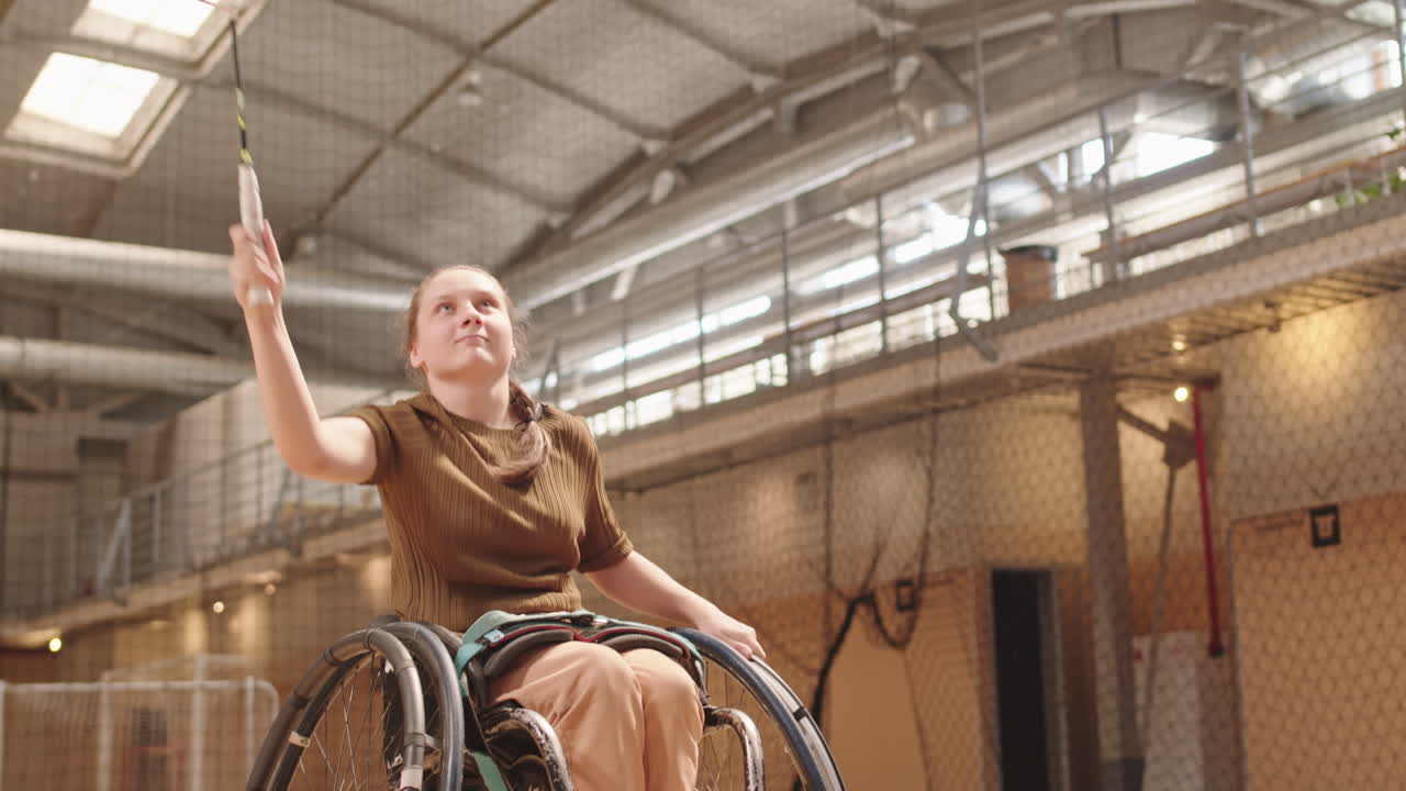 Teenager with Disability Hitting Shuttle with Badminton Racket