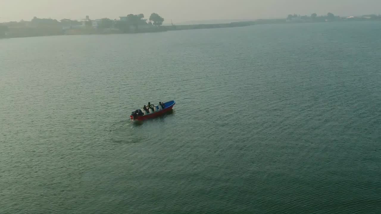 toma aérea de un barco en el lago keenjhar con un turista a bordo en thatta, pakistán al atardecer