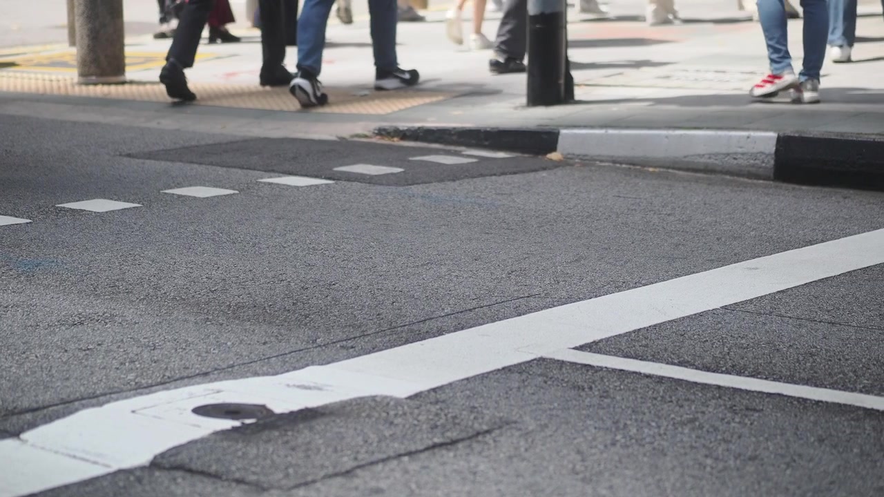 Pedoni che attraversano un passaggio pedonale in città