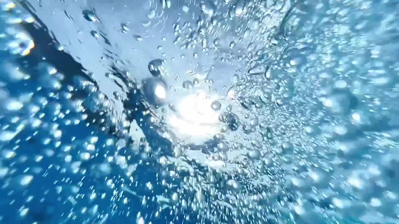 Underwater shot looking up at air bubbles floating toward the surface with bright sunlight refraction. Ideal for beverage commercials, wellness campaigns, and travel ads.