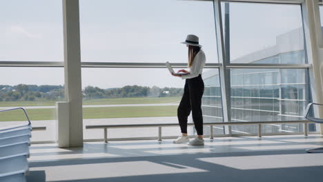 mujer trabajando en una computadora portátil en el aeropuerto