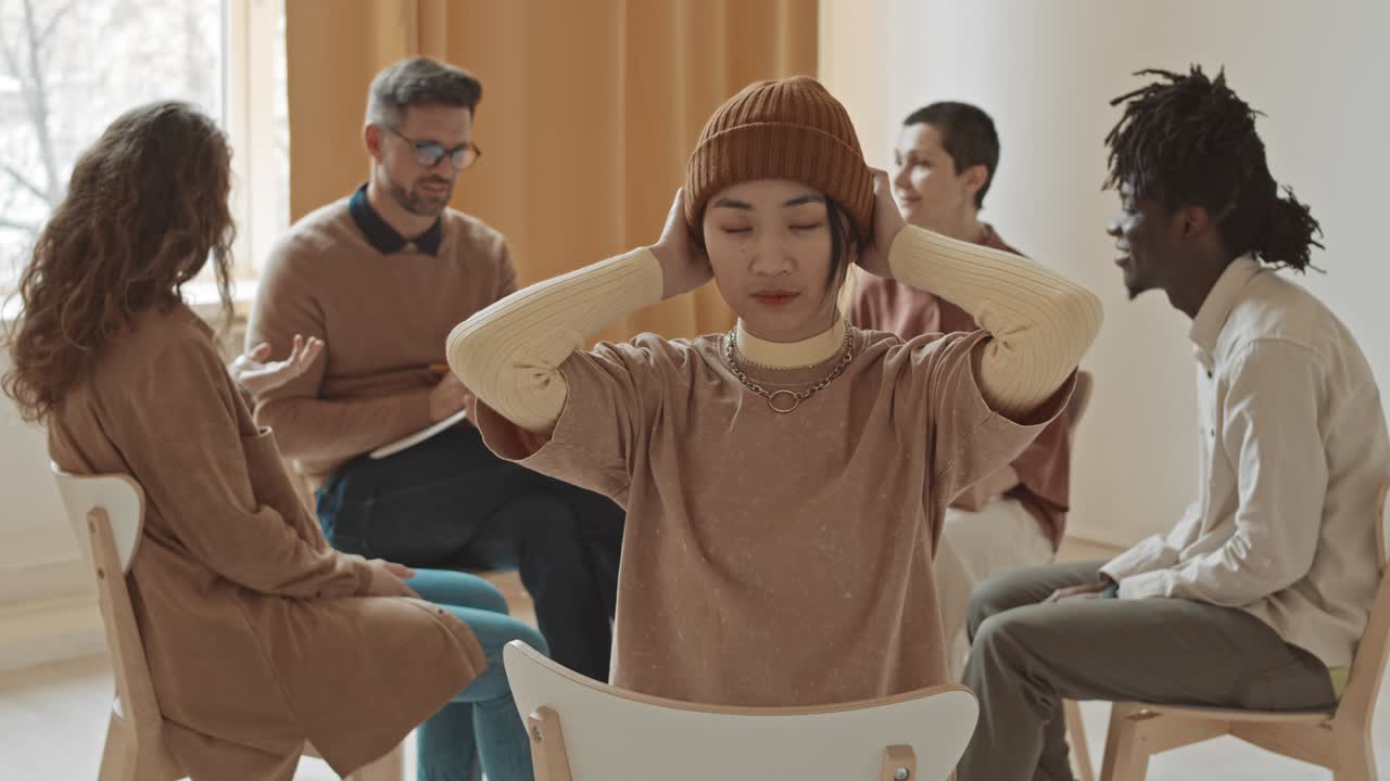 그룹 치료 세션에서 비니를 입은 스터 젊은 여성의 초상화