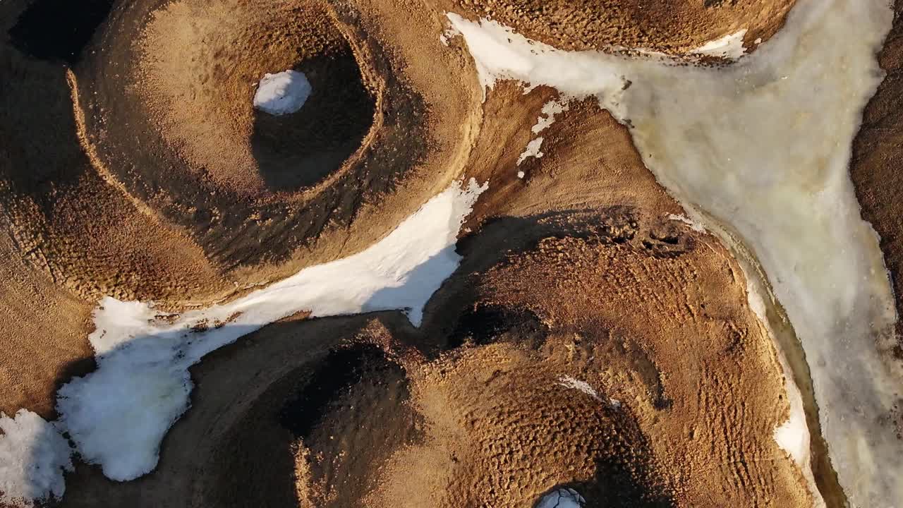 Top-down shot of snow-lined volcanic pseudocrater at Skútustaðir near Lake Mývatn. Reykjahlíð, Iceland