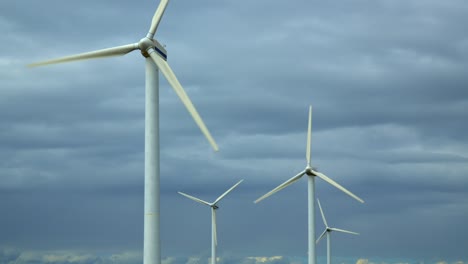 wind turbines rotating against bright stormy summer sky