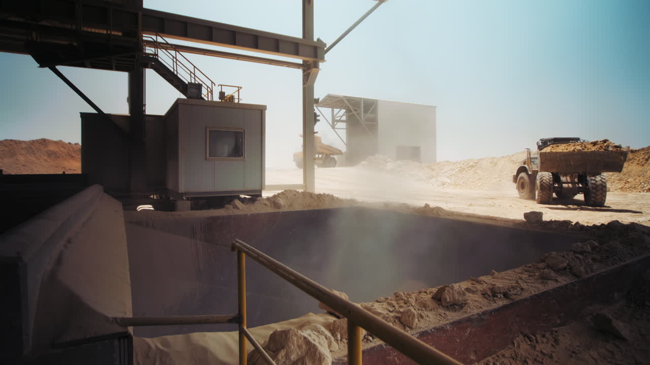 Industrial sand mining. Loader working at sand area. Dolly right, loading and dumping sand into a mill, Industrial machinery at sand quarry. 4k footage.