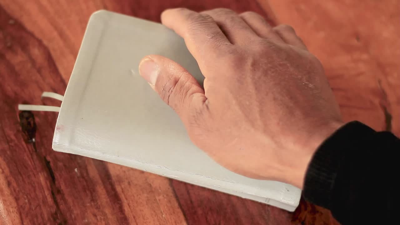 갈색 탁자가 있는 성경에 손을 얹고 기도 스톡 비디오