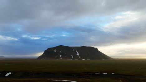 Aerial-time-lapse,-landscape-view-of-Petursey-Mountain,-Iceland,-with-a-dramatic-cloudscape,-at-dusk