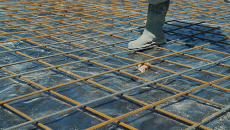 el trabajador conecta hábilmente las barras de la armadura con preparación de alambre para verter hormigón i