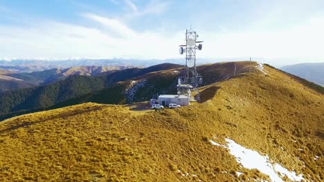 cinematic aerial shot of communication tower a top mount grey, new zealand