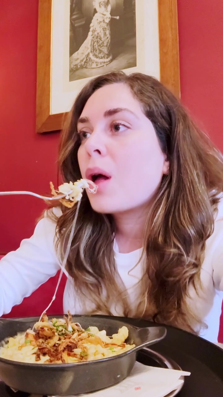 Peynirli makarna yemeğinin tadına bakan influencer kadın.