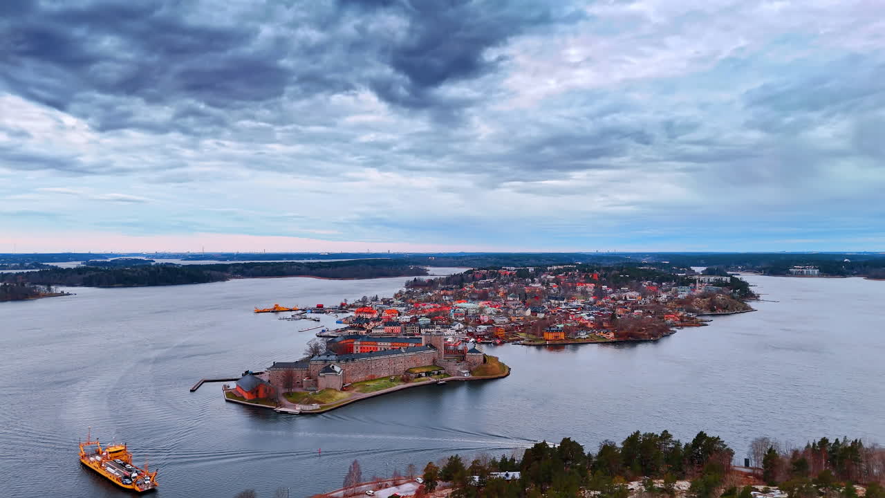 Paisaje aéreo de la fortaleza de Vaxholm y el puerto de la ciudad. Amplia toma panorámica del histórico castillo de piedra y la ciudad costera adyacente con embarcaderos