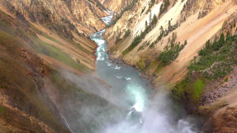 mist from the lower falls of the yellowstone river blows downstream