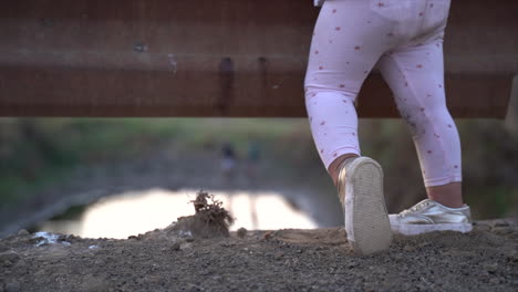 small south african black girl dancing on a low bridge in a winter landscape