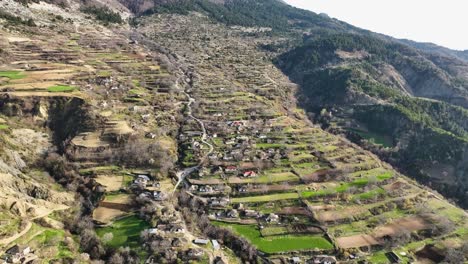 Rural-village-situated-on-mountainside-with-farming-fields-nearby