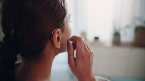 woman adjusting her hearing aid