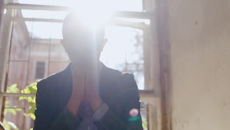 Stressed-Young-Man-Sits-By-Window-Silhouetted-By-Sun