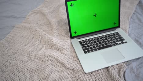 computadora portátil con pantalla verde en una cama. concepto para chats de video de aprendizaje a distancia virtual remoto.