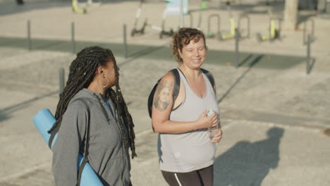 handheld shot of happy diverse women going home after training