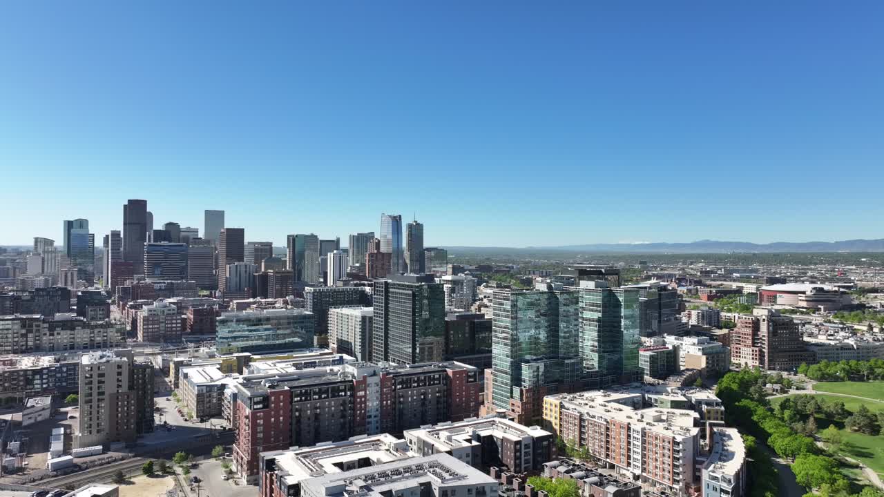 Vista aerea del centro di Denver che mostra i moderni grattacieli sotto un cielo azzurro, drone che vola all'indietro