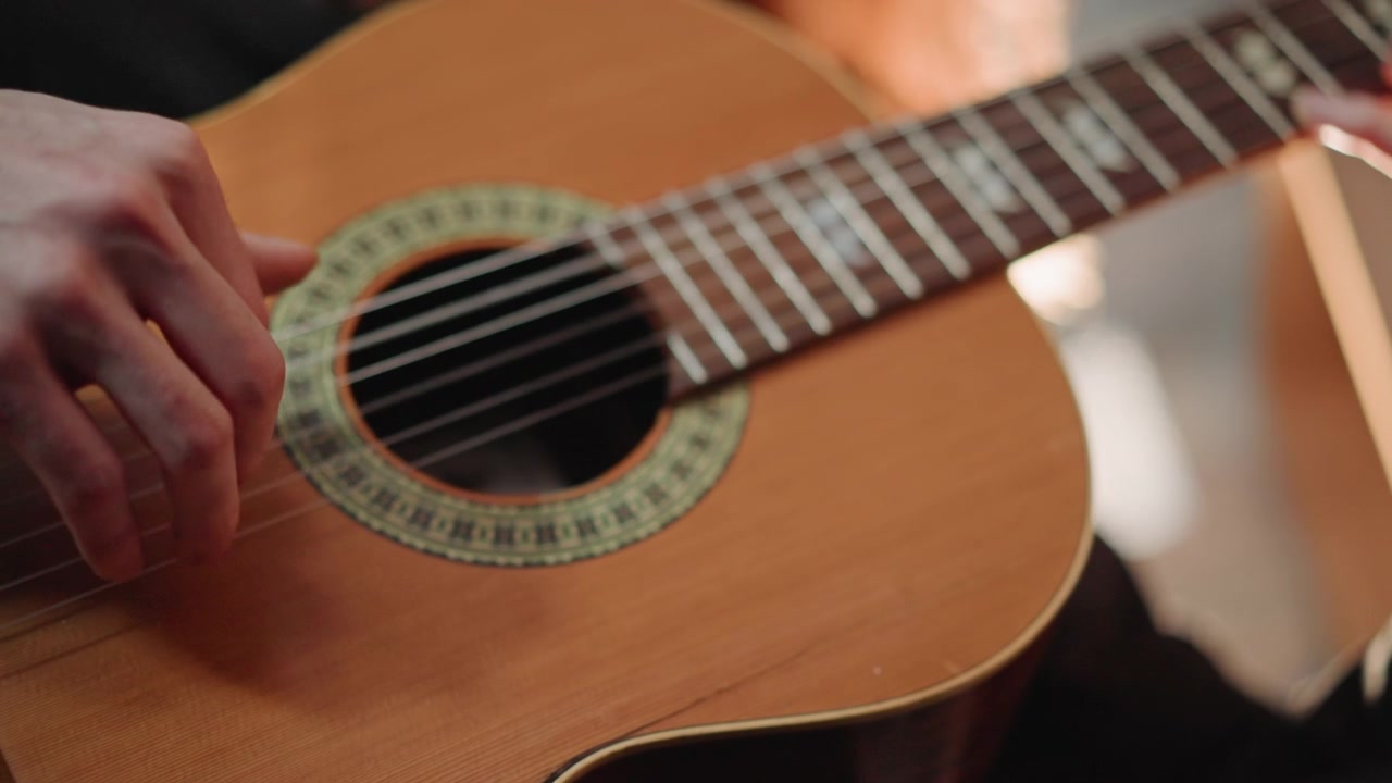 Guitarist demonstrating technique. Closeup of guitarist with nylon string technique. Studio environment showcasing musician demonstrating accurate righthand plucking on classical guitar