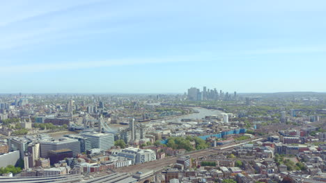 dolly forward drone shot over south london towards canary wharf and tower bridge