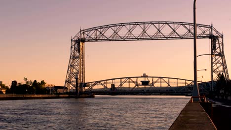 cargo ship passing through duluth lifting bridge