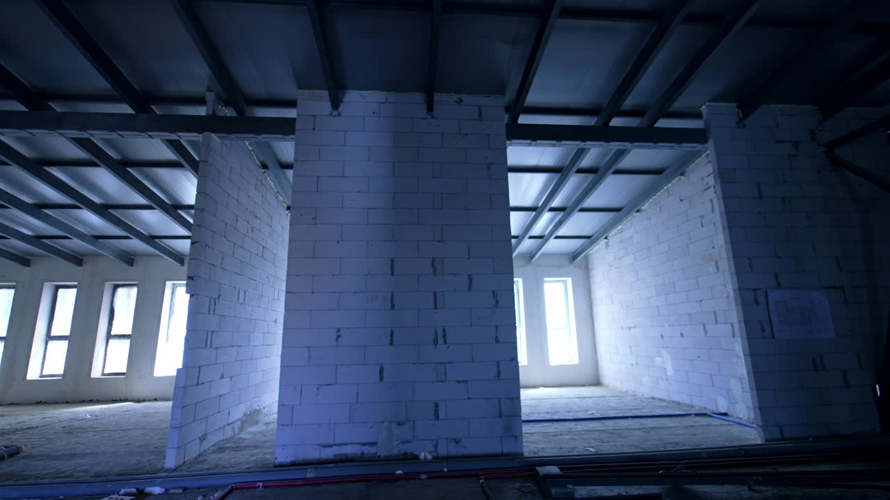 Interior of the renovated building. Newly built white brick walls under the new roof. Low angle view.