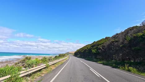 a serene drive along great ocean road, showcasing coastal landscapes, clear skies, and lush greenery under bright daylight