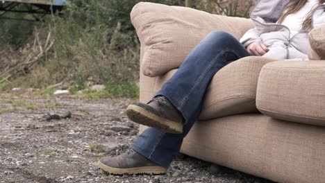 woman relaxing on sofa in outside yard medium shot