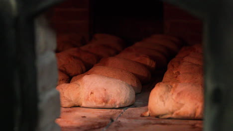 loaves of bread being cooked inside the traditional oven in the bakery