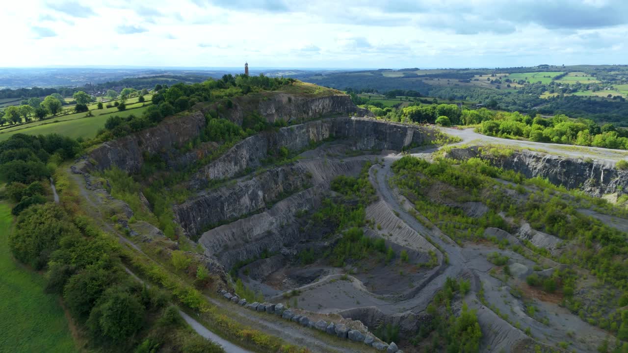 Drone panorama of old stone quarry near Crich village showing industrial pits, mining remains, and natural green landscape, England