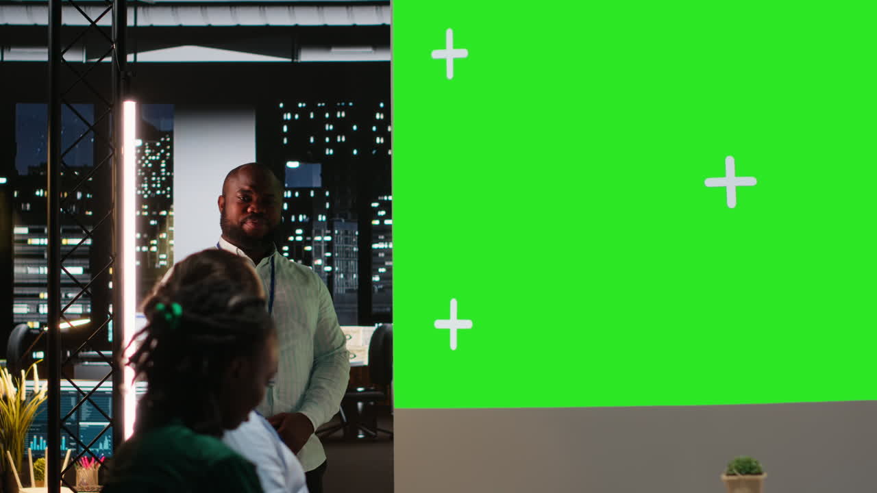 Black male supervisor hosting a late meeting with chroma key display