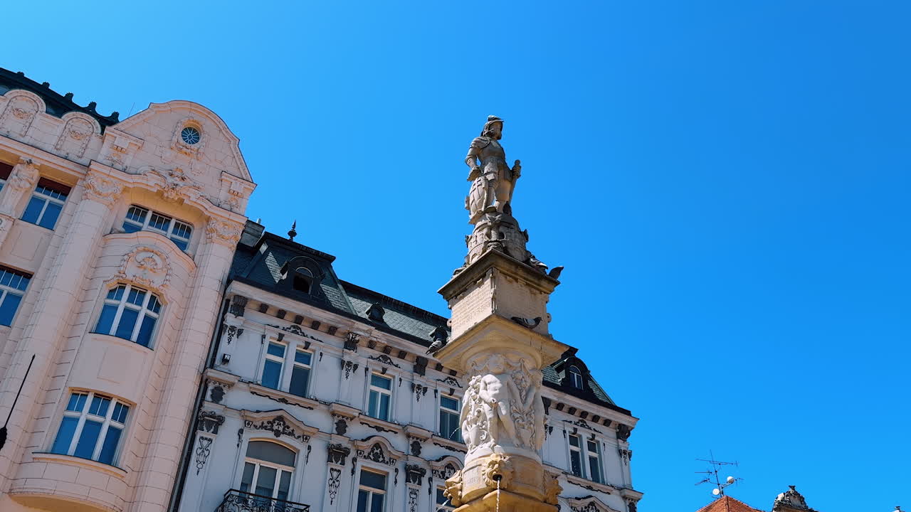 Bratislava, Slovakia, 2 June 2025: Pigeons sit on the beautiful sculpture of Roland Maximillian fountain. Low angle view. Old historical buildings of Bratislava, Slovakia at backdrop