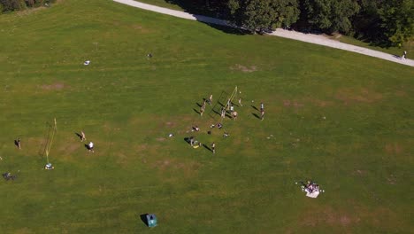 Smooth-aerial-top-view-flight-Volleyball-court-English-Garden-Munich-Germany-Bavarian,-summer-sunny-blue-sky-day-23