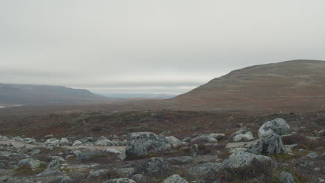 Bewölkte-Landschaft-Mit-Felsen-Im-Vordergrund-Und-Bergen-Im-Hintergrund-In-Lappland