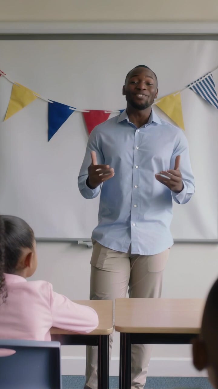 Vertical video: Starting lesson, blue-shirted teacher gesturing to engage kids, classroom bunting