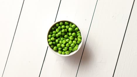 fresh green pea seeds in a white ceramic bowl