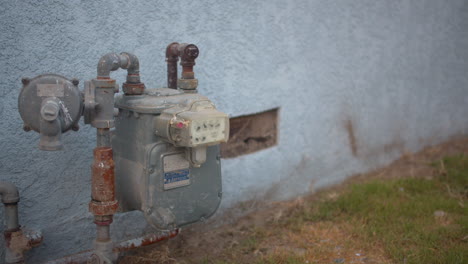 Electricity-meter-against-a-blue-house