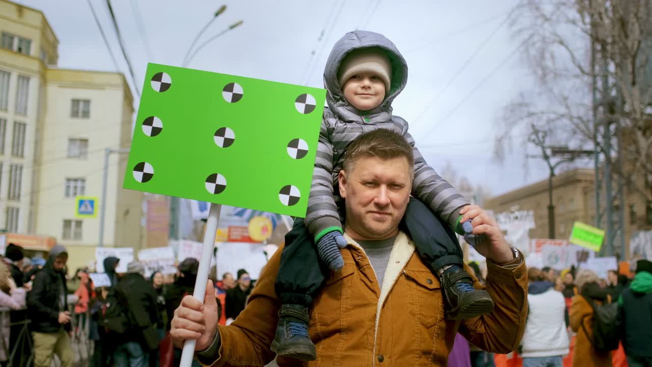 Demonstration of single father with greenscreen banner. Dad and son activists.