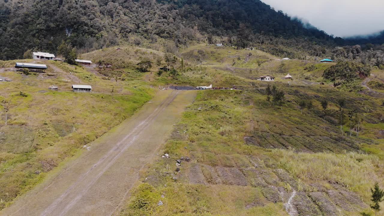 imágenes aéreas de un pequeño avión en una pista de montaña en las selvas de papúa, indonesia