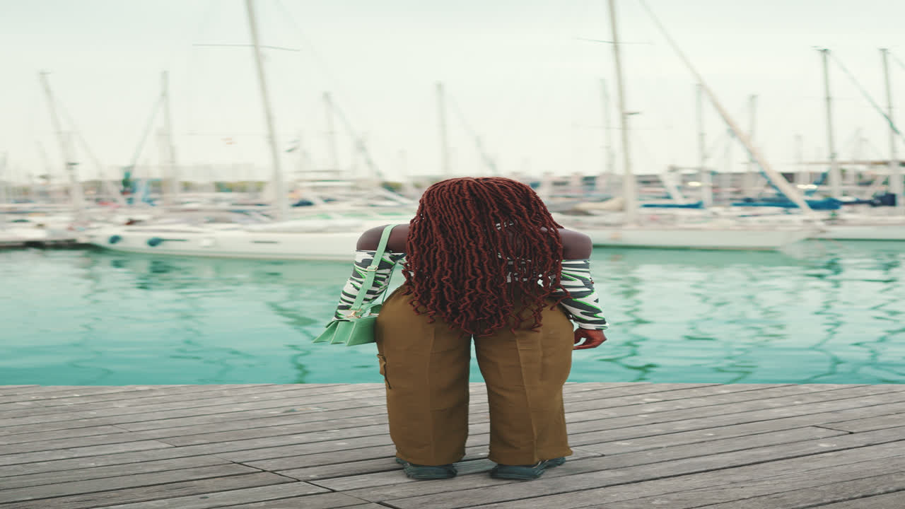 Kvinde med dreadlocks i lystbådehavnen