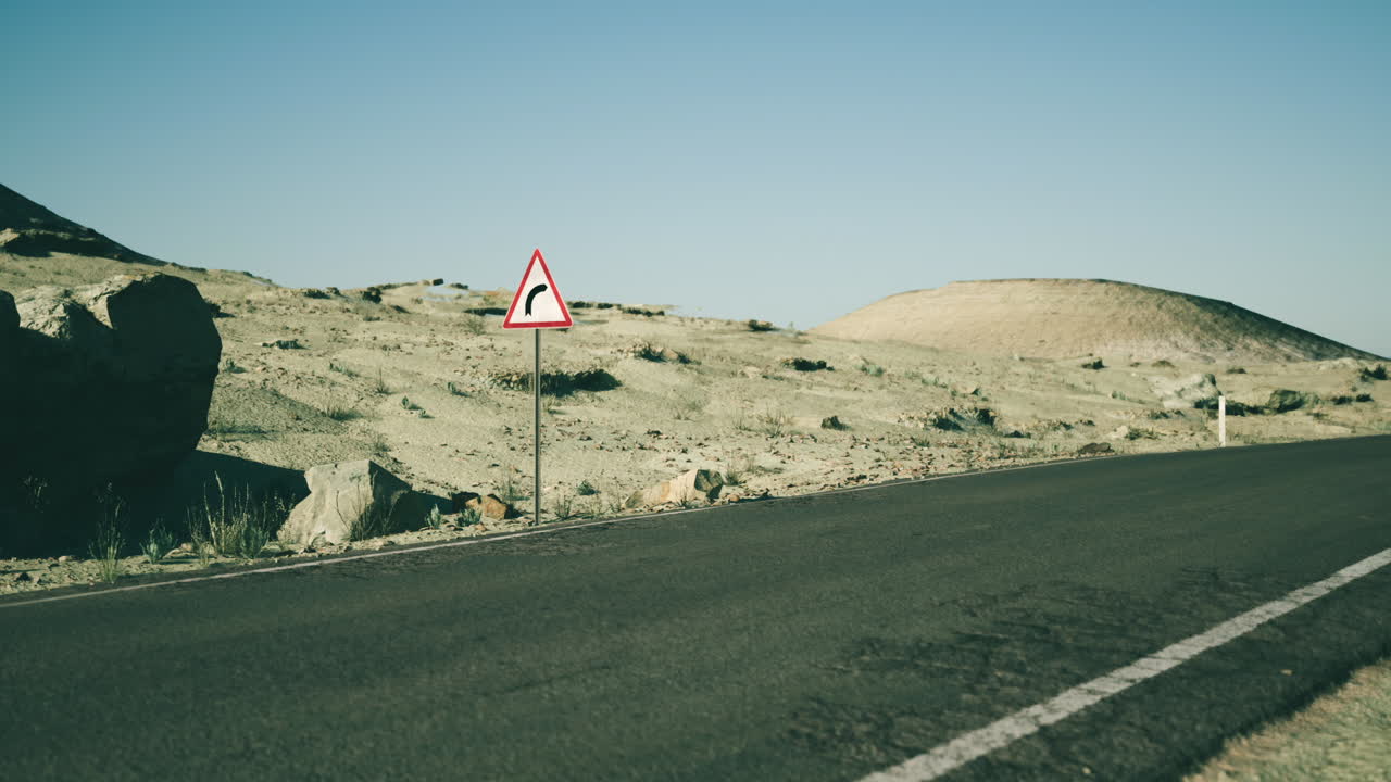 황폐 한 도로 에 있는 곡선 경고 표지판