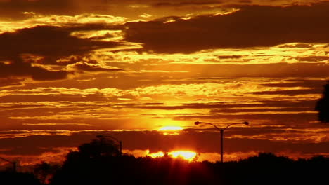 The-sun-glows-behind-clouds-in-a-red-and-orange-sky