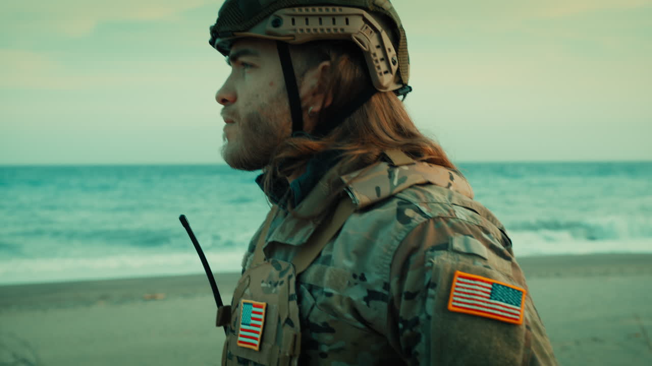 Charming American soldier with long hair wears protective helmet