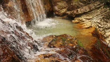 Cascada-Relajante-En-La-Roca-Naranja,-Primer-Plano-Lateral,-60-Fps